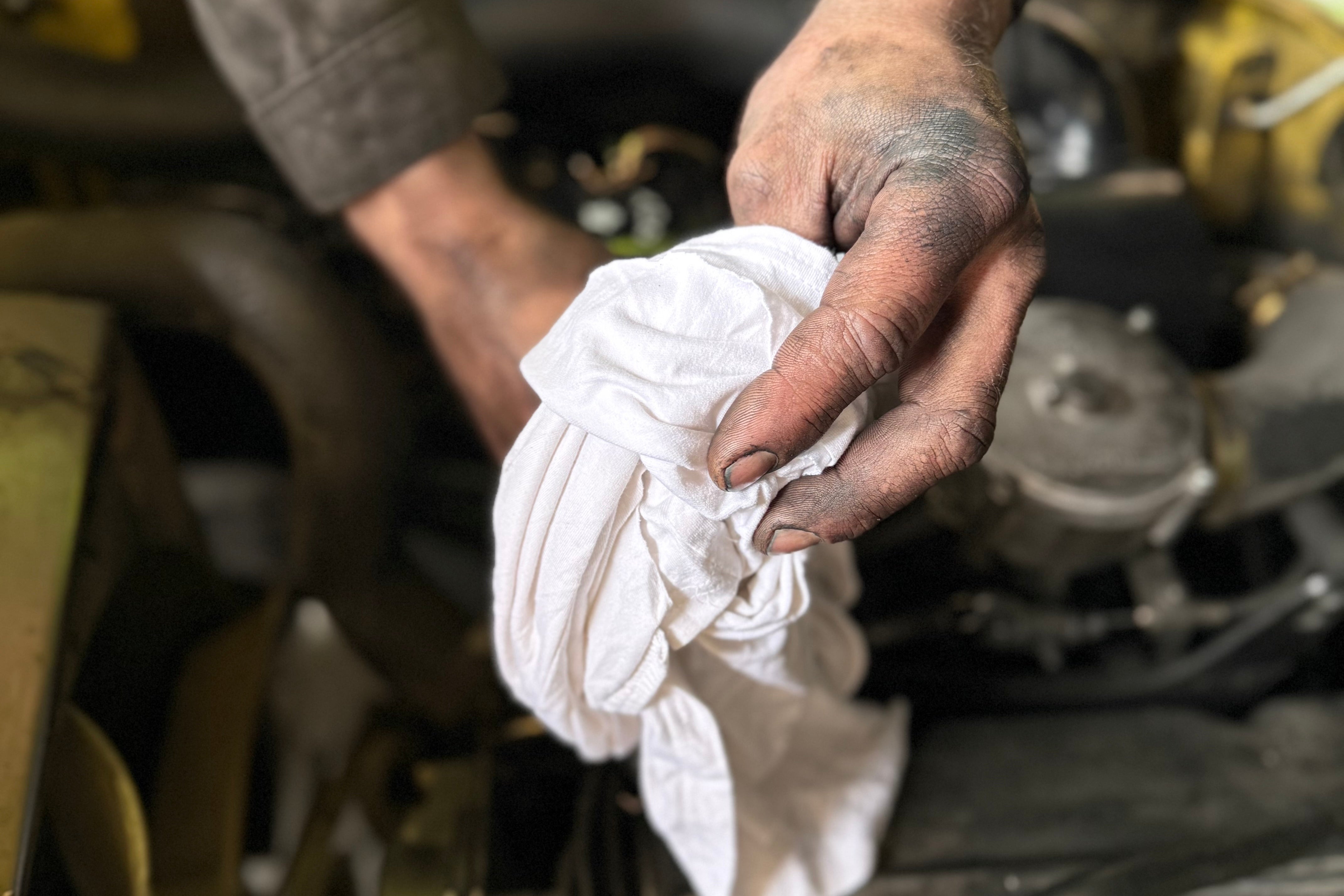 eine schmutzige Hand mit einem weißen Trikot Putzlappen