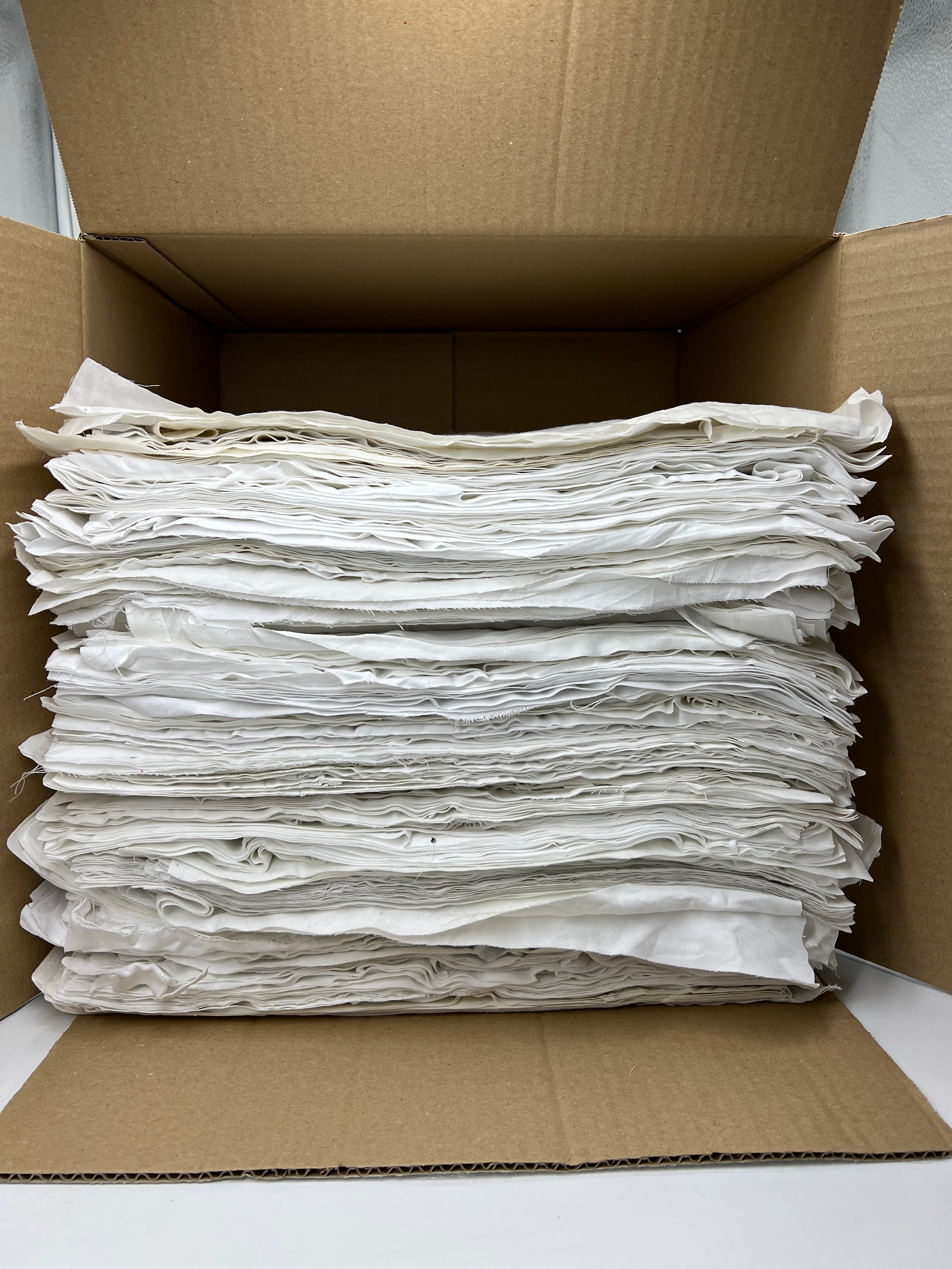 Gewerbe-Putzlappen Kattun: Stapel weißer, geschnittener Industrieputzlappen für den Großhandel.